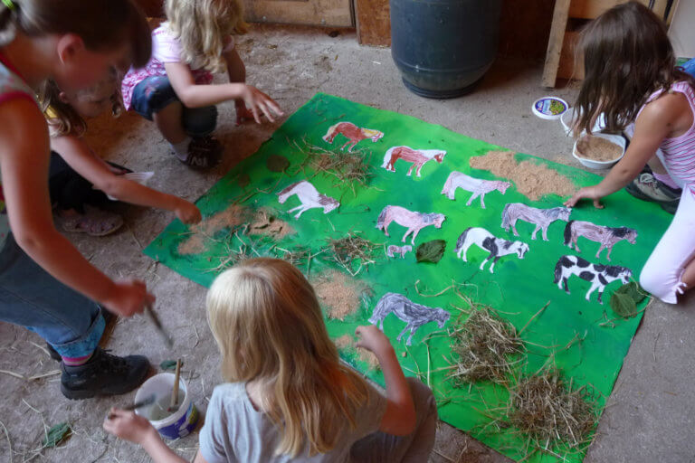 Kinder gestalten ein Plakat mit Pferden
